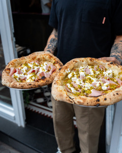 Zwei frisch gebackene Pizzen werden serviert