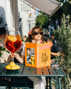 Frau genießt Aperol Spritz in einem Außenbereich von Gotti Pizza